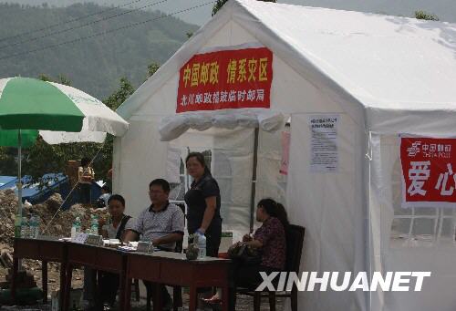  5月22日，位于北川县擂鼓镇地震灾区、已经挂牌营业的北川邮政擂鼓临时邮局工作人员正在等待顾客。